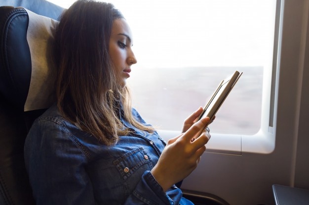 Dame læser e-bog i et tog